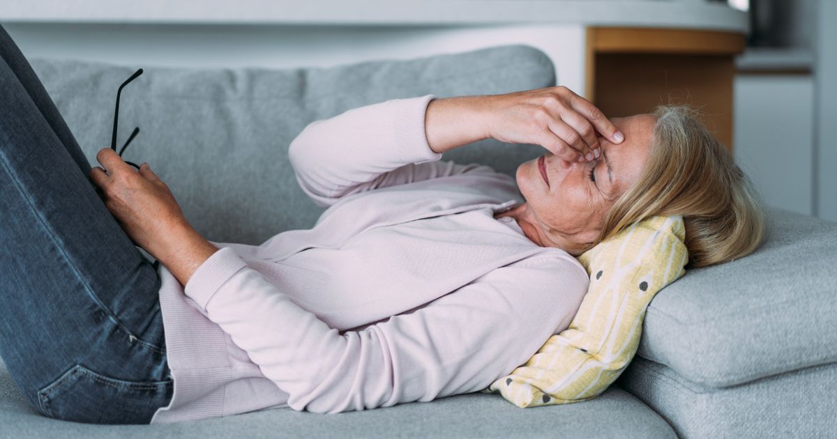 Woman on couch with headache.