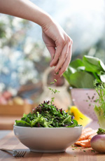 Dropping salad into a bowl