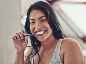 woman smiling and brushing teeth