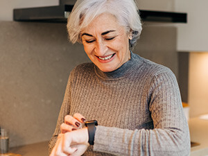 smiling woman looking at her smartwatch