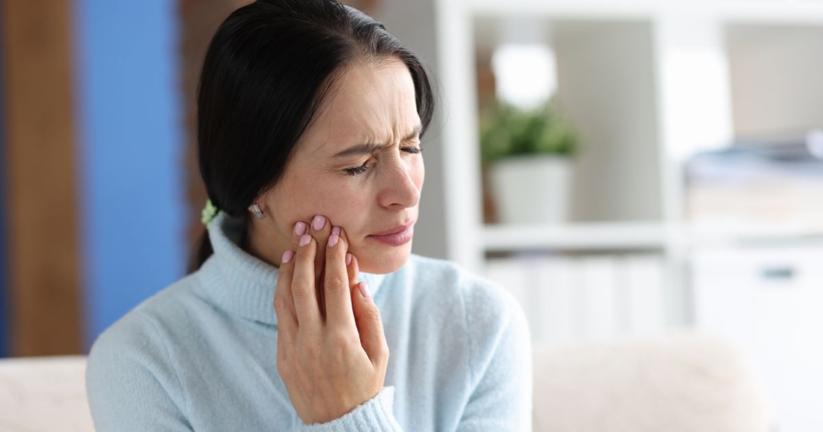 Woman grabbing jaw.