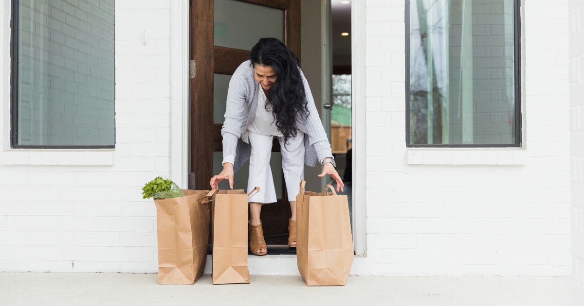 Woman lifting groceries.