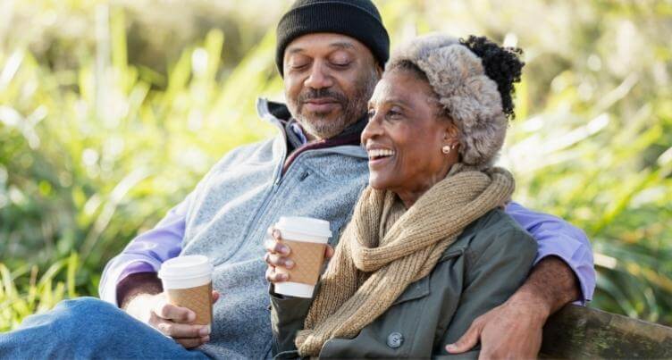 Couple drinking coffee outside.