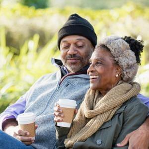 Couple drinking coffee outside.