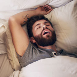 couple in bed with man snoring