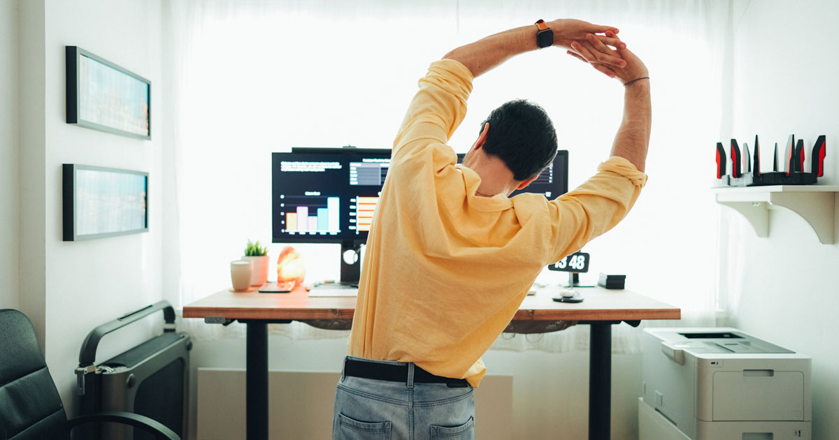 Man stretching by computer