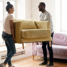 man and woman moving sofa