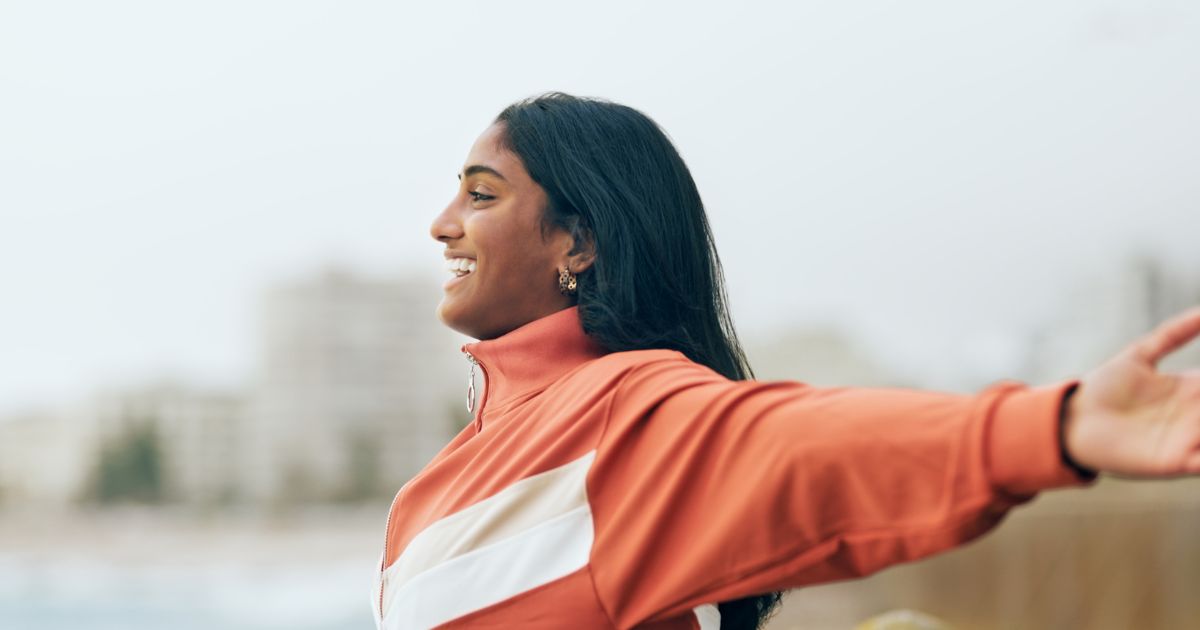 Woman smiling with outstretched arms.