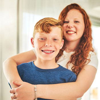 mom embracing son wearing braces
