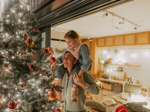 mom and daughter decorating tree