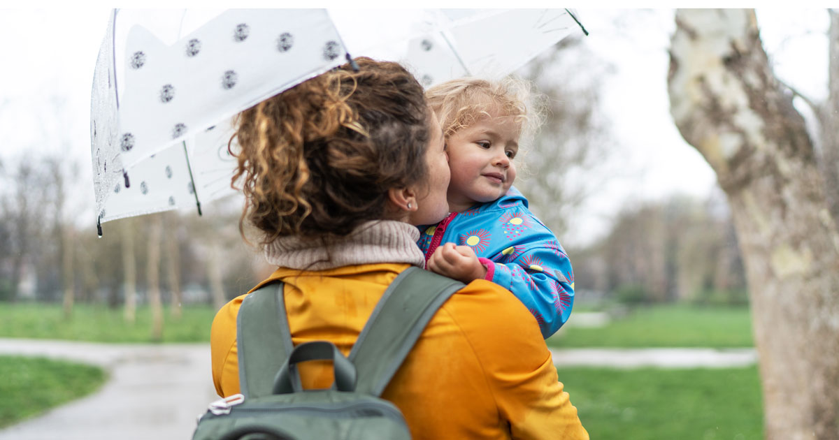 Mother holding daughter wearing a backpack