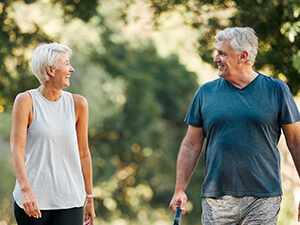 woman and man walking their dog outdoors