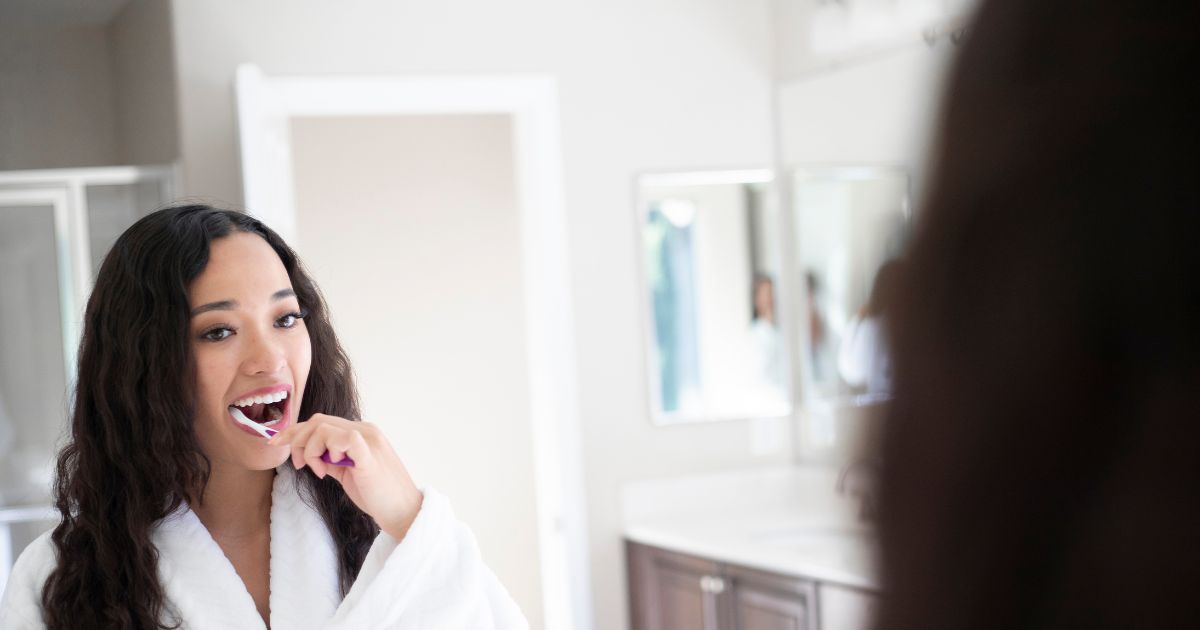 Woman brushing teeth.