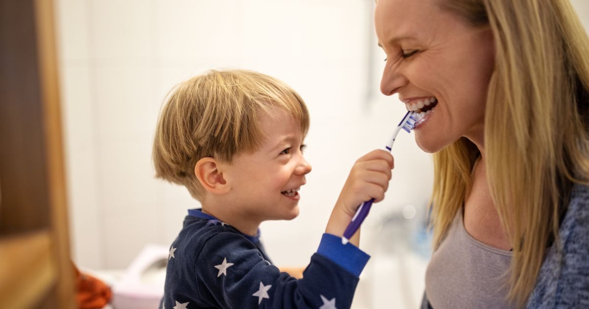 Child brushing mum's teeth