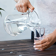 person pouring water into a glass