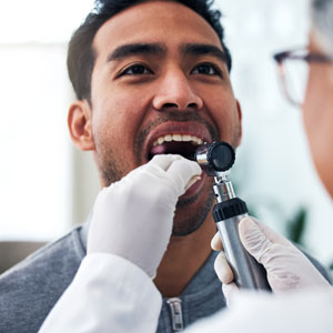 Patient getting checked for oral cancer