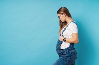 Pregnant woman holding stomach.