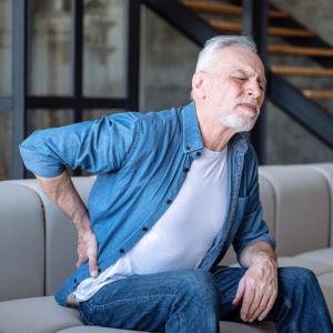 Man with pinched nerve in back on couch.