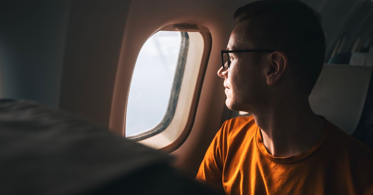 Man looking out plane window.