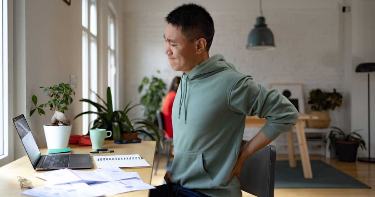 Man in pain at desk.