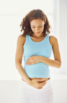 Woman holding pregnant stomach.
