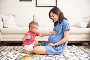 pregnant woman playing with toddler