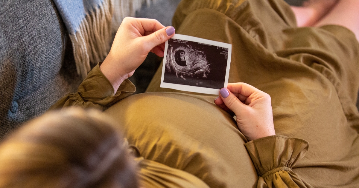 Woman holding sonogram.