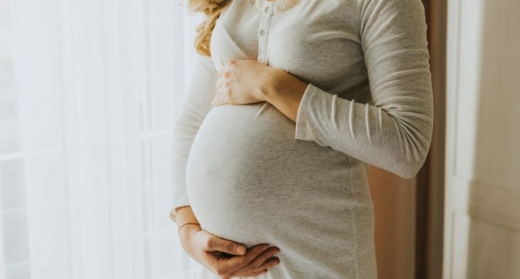 Woman holding pregnant belly.