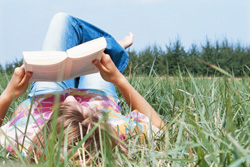 Woman reading a book in the grass