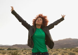 A women standing outside with her arms stretched out