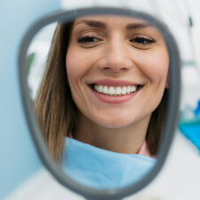 woman looking in hand mirror