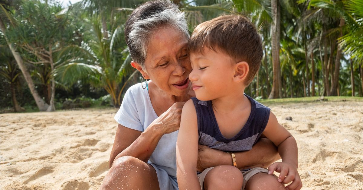 Grandmother and Grandson playing on a beach.