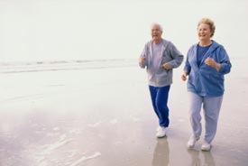 Seniors running on beach together