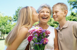 Children kissing smiling grandmother