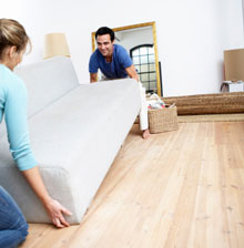 two people lifting a couch