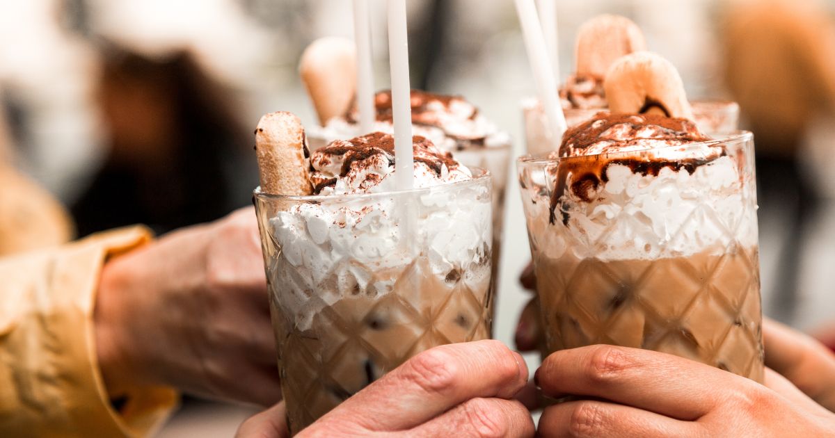 People holding iced coffee.