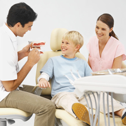Dentist and dental assistant with smiling young boy
