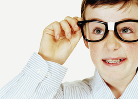 Boy with braces squinting through joke glasses