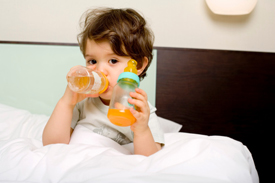Child drinking juice in bed
