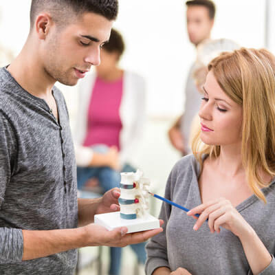 Two people looking at spine model