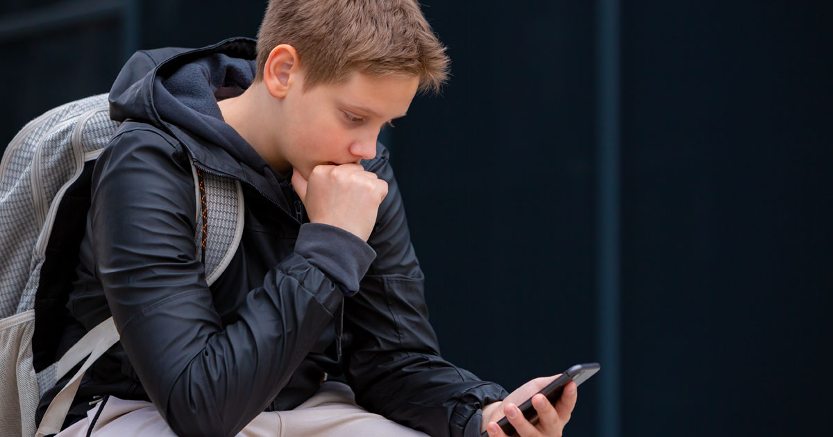Teen looking down at phone