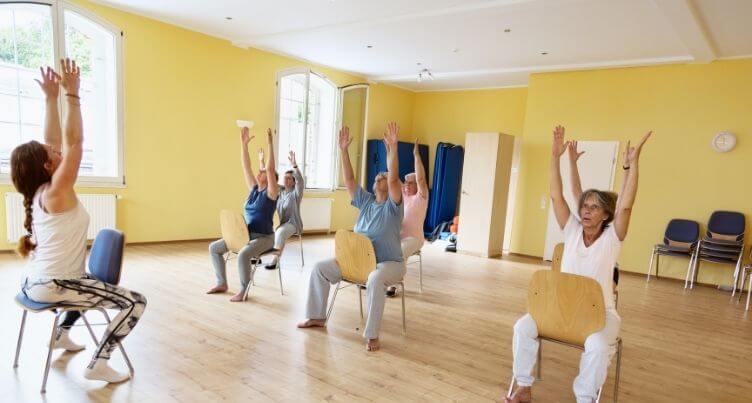 Seniors doing chair yoga.