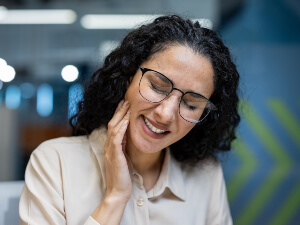 woman with glasses having jaw pain