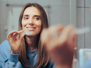 woman putting mouthguard into mouth
