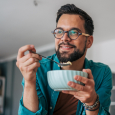 man eating bowl of food and smiling