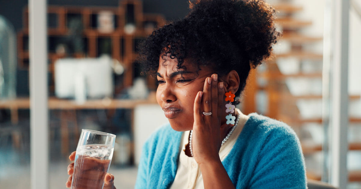 woman drinking ice water and touching mouth in pain