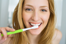 Closeup of young woman brushing her teeth