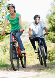 Man and woman riding bikes and laughing