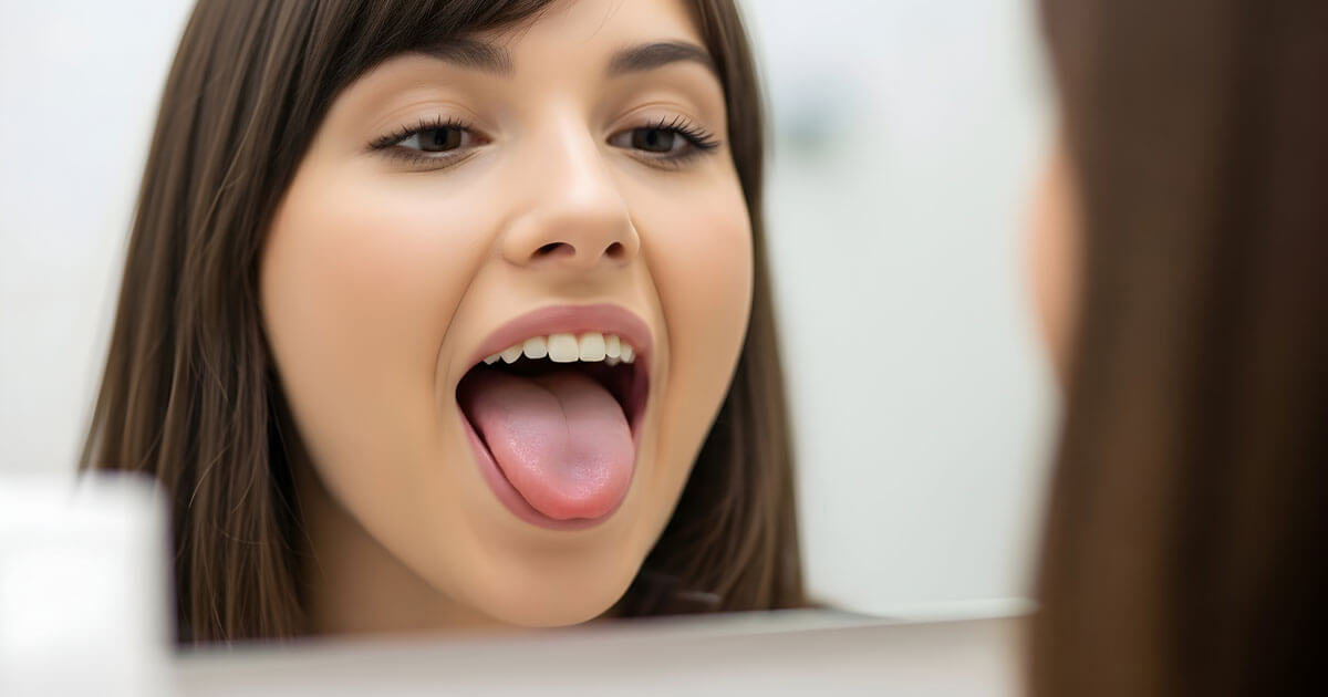 woman inspecting her tongue in a mirror