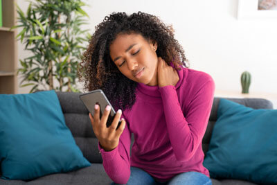 woman with neck pain making a phone call